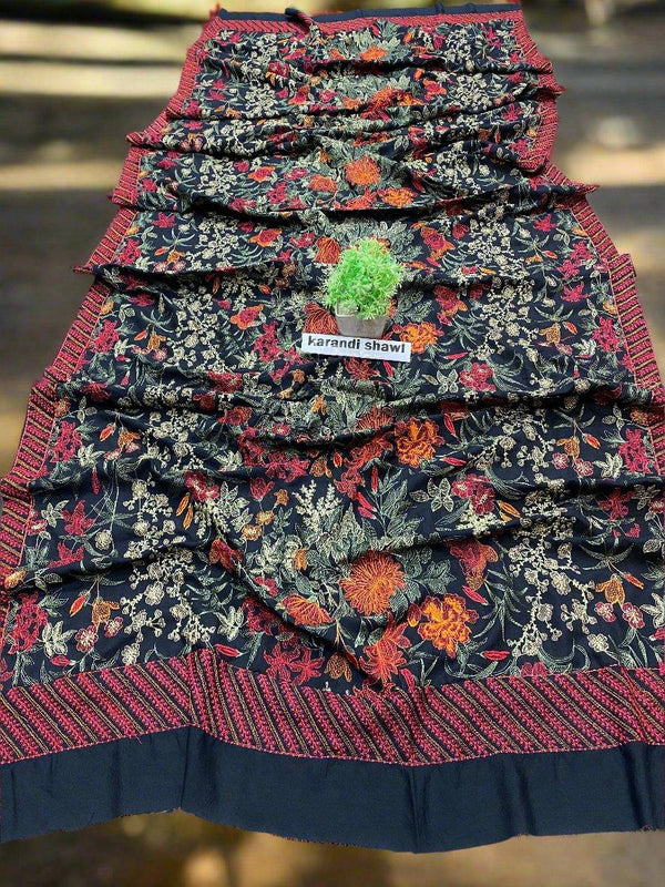 The Majestic Flame Bareeze by ESHMEEN is a beautifully patterned fabric showcasing rich dark tones with intricate floral designs in red, orange, and white. As part of the winter collection, this heavy embroidered karandi shawl includes visible green thread on its surface for added elegance.