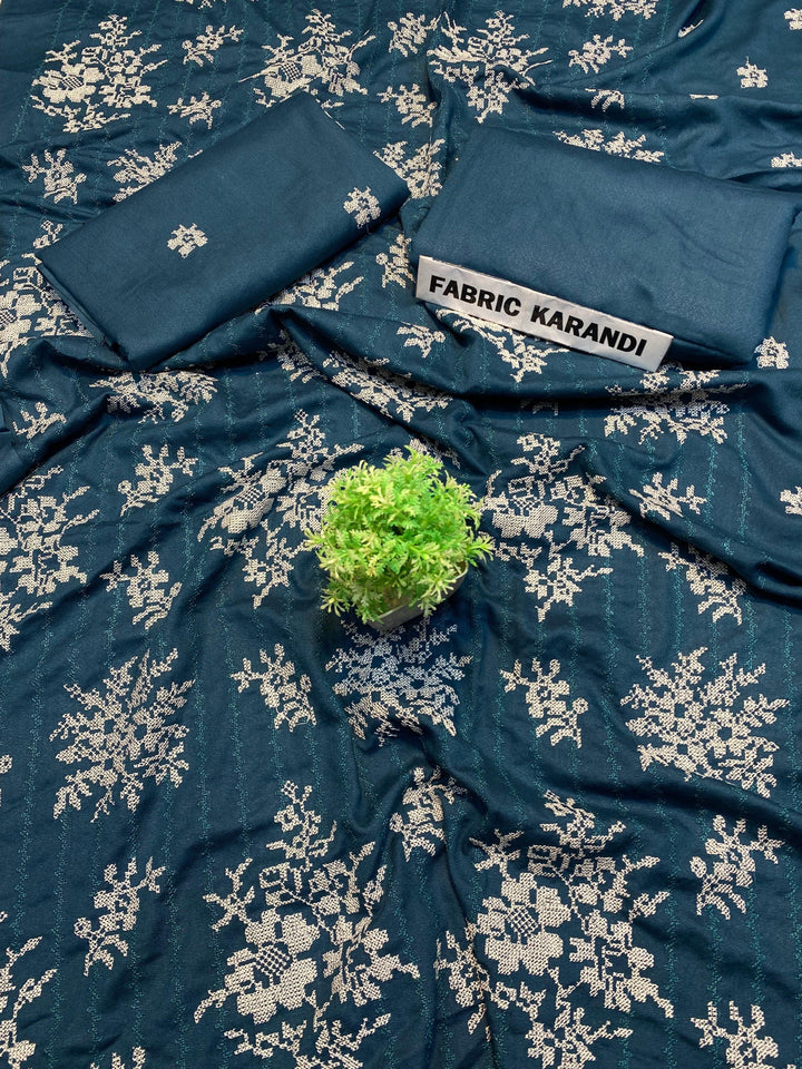 The black fabric adorned with white floral embroidery is presented, highlighted by a small green plant at its center. In the upper right corner, a label reveals "Regal Hues Bareeze" from ESHMEEN's Winter Collection, emphasizing its premium quality.