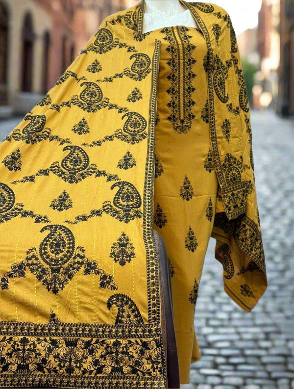 A display featuring the Bareeze Crimson Horizon fabric from ESHMEEN draped over a mannequin, set against a cobblestone street background. The intricate patterns and vibrant colors of this piece from the winter collection truly stand out, highlighting its elegance.