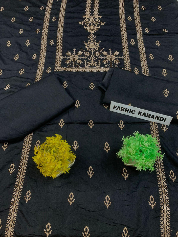 Regal Dusk Bareeze from ESHMEEN showcases beautifully intricate blue patterns on purple fabric, with two artfully folded pieces labeled as part of the Winter Collection. A small yellow bouquet is elegantly placed at the center on this premium quality fabric.